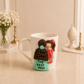 Mint Blossom Mug - white ceramic mug sculpted with a mother in a mint green dress lettered THE BEST MOM holding a baby in coral