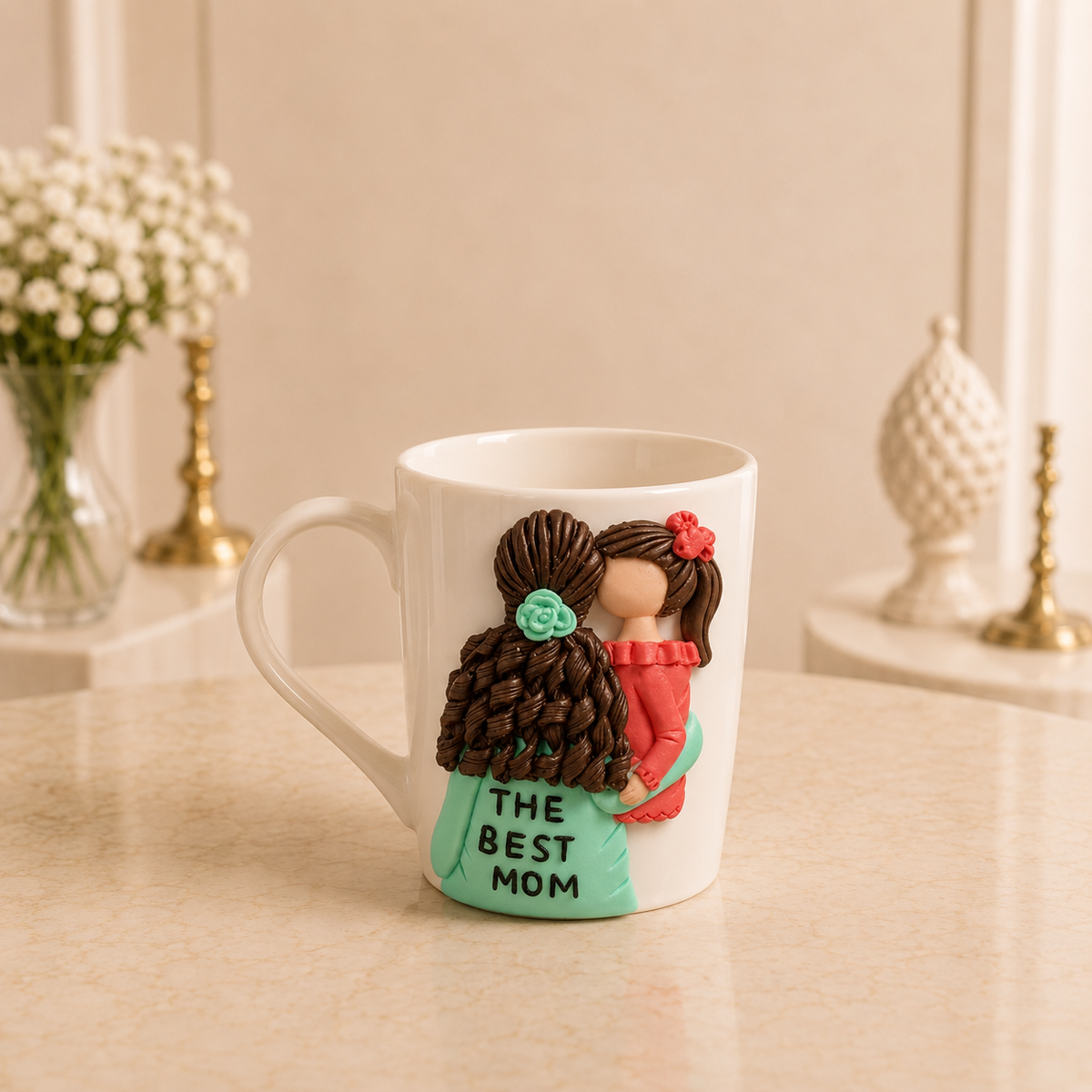 Mint Blossom Mug - white ceramic mug sculpted with a mother in a mint green dress lettered THE BEST MOM holding a baby in coral