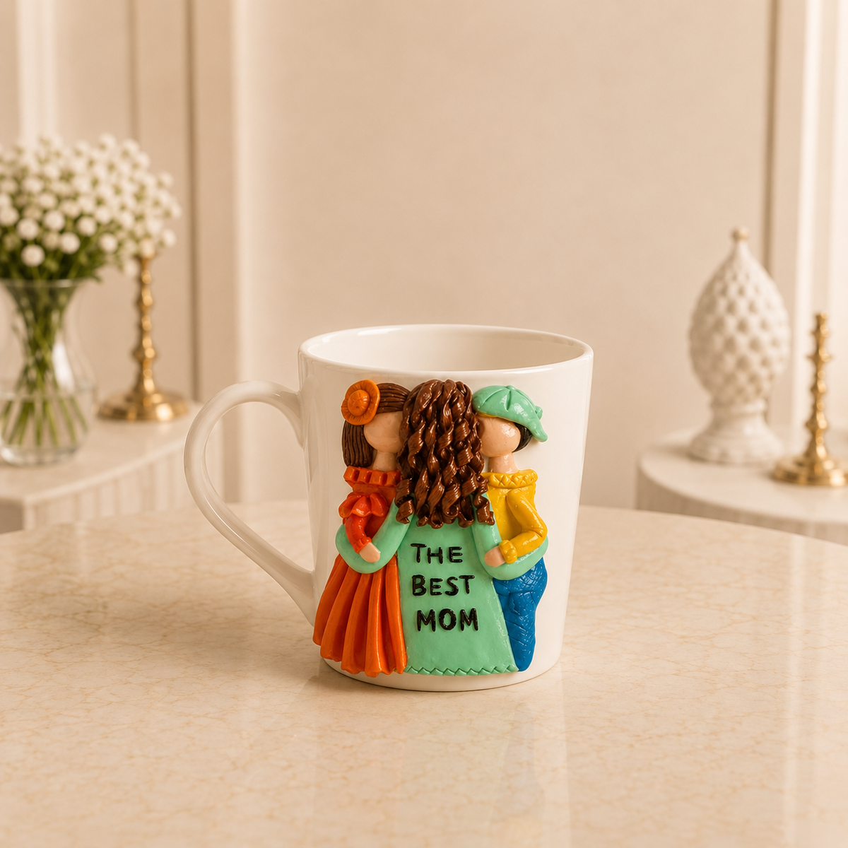 Mint and Marigold - white ceramic mug sculpted with a mother in mint green lettered THE BEST MOM with a girl in orange and a boy in yellow