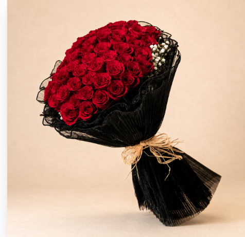 Red Rose Bouquet - Grand - 50 red roses bouquet in black mesh wrap with raffia bow, clean beige background